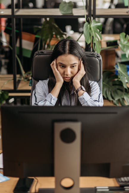 tired person looking at computer screen with strained eyes in office environment